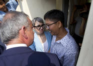Reuters journalist Wa Lone, right, is welcomed by Reuters officials as he was released from Insein Prison in Yangon, Myanmar Tuesday, May 7, 2019. Two Reuters journalists who were imprisoned for breaking Myanmar's Official Secrets Act over reporting on security forces' abuses of Rohingya Muslims were pardoned and released Tuesday, the prison chief and witnesses said. (AP Photo/Thein Zaw)