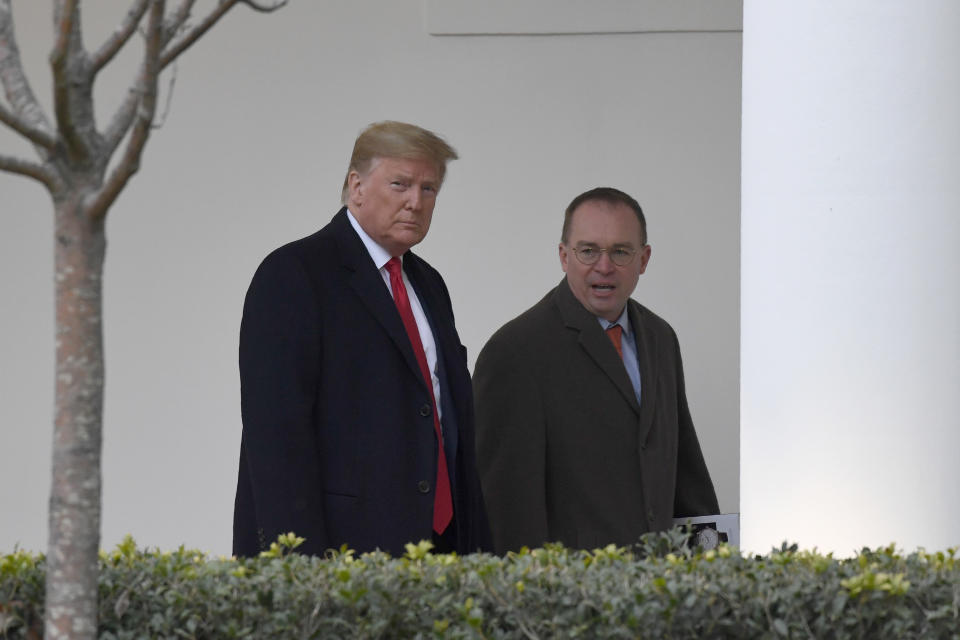 FILE - In this Jan. 13, 2020. file photo, President Donald Trump, left, and acting White House chief of staff Mick Mulvaney, right, walk along the colonnade of the White House in Washington. The federal government's watchdog agency says a White House office violated federal law in withholding security assistance to Ukraine aid. The Government Accountability Office said Thursday the White House Office of Management and Budget violated the law in holding up the assistance. (AP Photo/Susan Walsh, File)