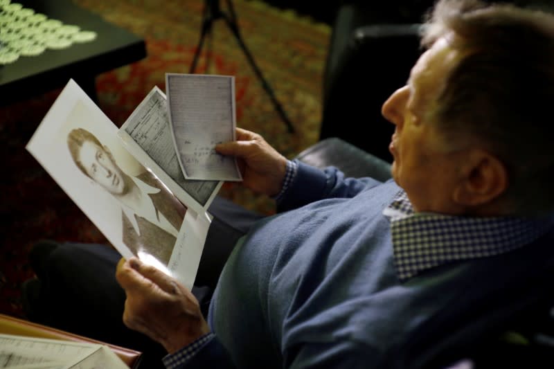 Holocaust survivor Avraham Harshalom, 95, looks at a photograph of himself as a young man during an interview with Reuters at his home in Ramat Gan, Israel