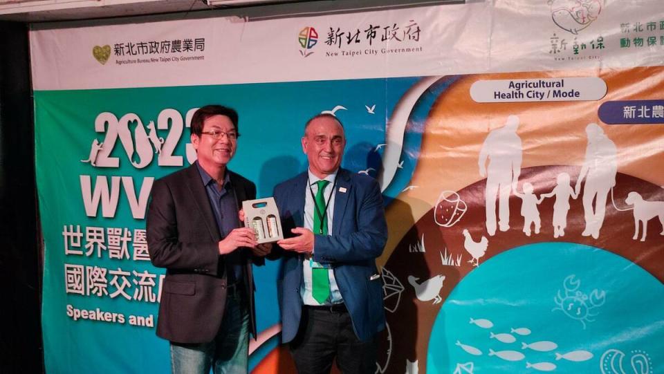 新北市副市長劉和然致贈茶慶酒給世界獸醫師會長拉菲爾。   圖：新北市動保處提供