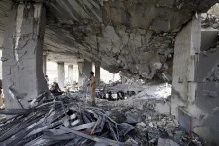 A Houthi militant poses for a photograph while standing on the rubble of a house destroyed by a Saudi-led airstrike in Yemen's capital Sanaa September 5, 2015. REUTERS/Mohamed al-Sayaghi