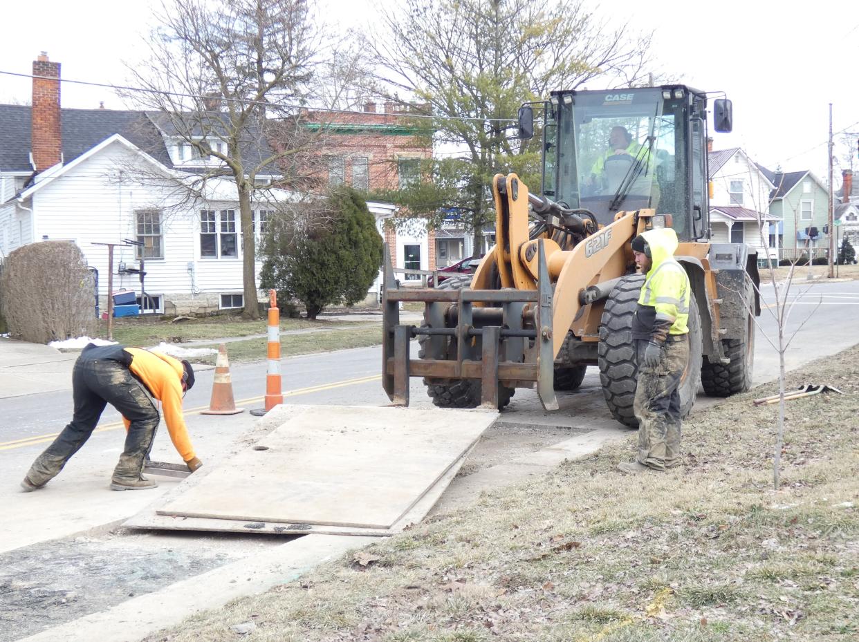 City workers complete repairs on a collapsed sewer line on Hopley Avenue between East Lucas and Rogers streets, just south of Bucyrus Elementary School, on Friday afternoon. From left are Dylan Scott and Anthony Bond.