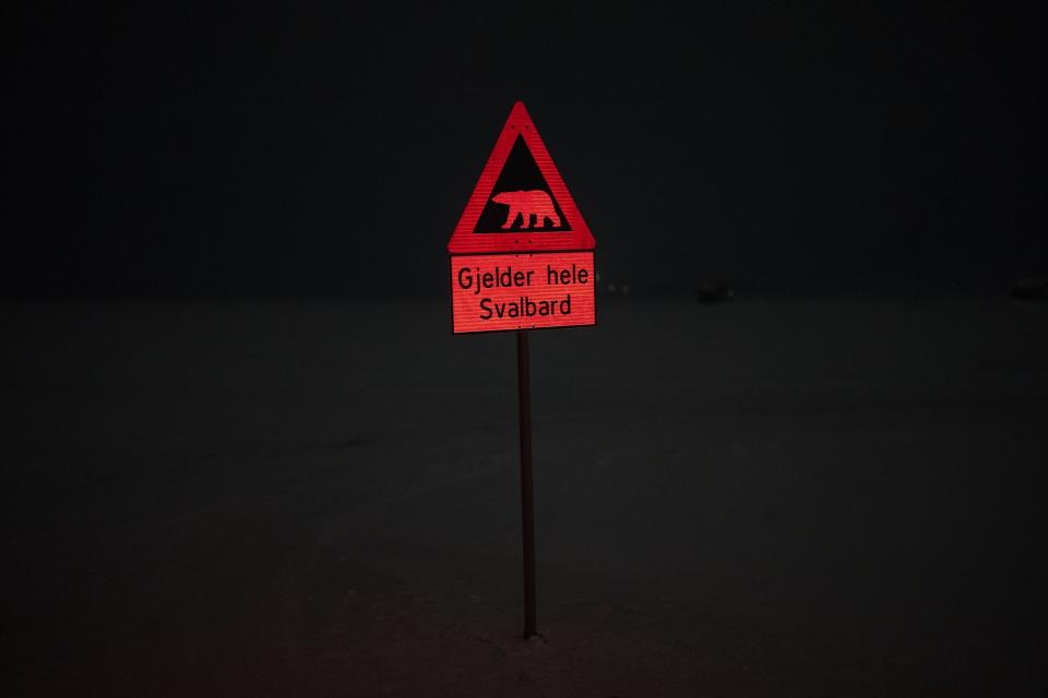 Un letrero indica el peligro de los osos polares en los límites del poblado de Longyearbyen, Noruega, el lunes 9 de enero de 2023. A todo el que trate de ir más allá de los límites de Longyearbyen, se recomienda llevar protección, como una pistola de bengalas y un arma de fuego, una advertencia de que los lugareños toman muy en serio. (AP Foto/Daniel Cole)