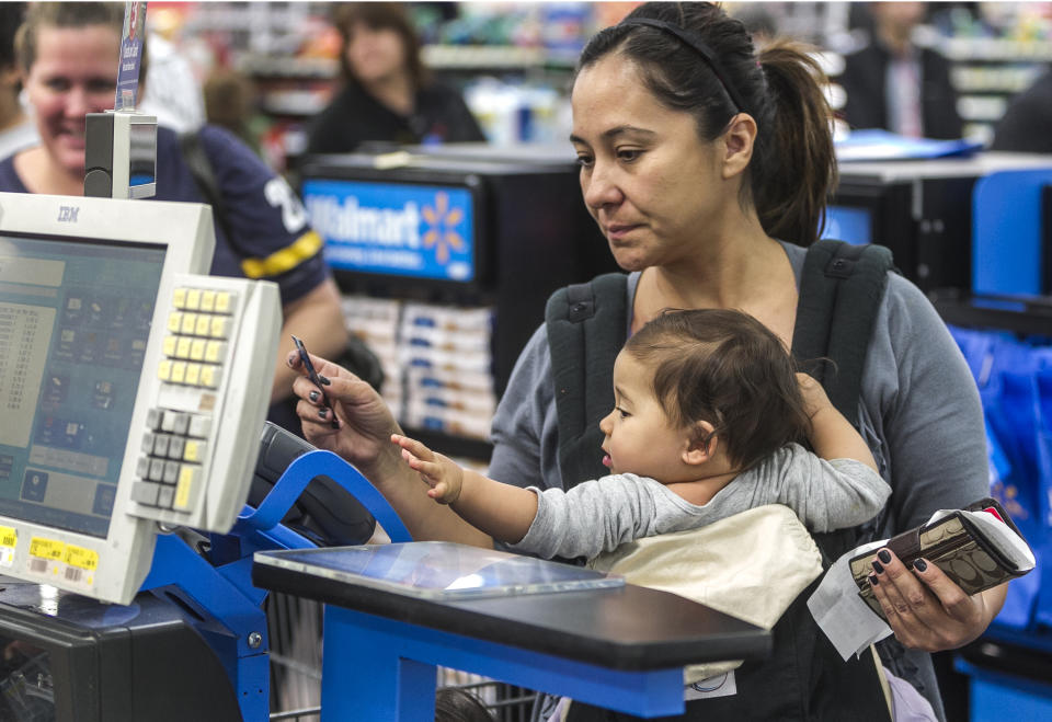 Consumer Eva Cevallos with her eleven-month daughter, Quinn, pays with a credit card, as she shops at the Walmart Supercenter store in Rosemead, Calif.(Damian Dovarganes, AP Photo)