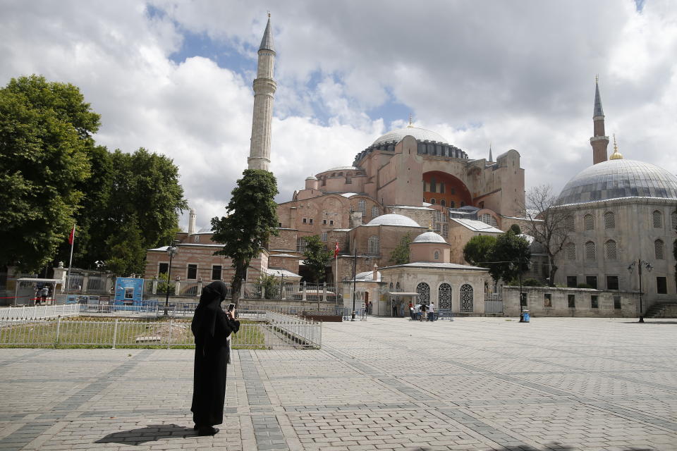 A Womacks takes photos of the Byzantine-era Hagia Sophia, an UNESCO World Heritage site and one of Istanbul's main tourist attractions in the historic Sultanahmet district of Istanbul, Friday, July 10, 2020. Turkey's Council of State, the country's highest administrative court is expected to release a ruling on a petition requesting that a 1934 decision that turned the Hagia Sophia into a museum be annulled. (AP Photo/Emrah Gurel)