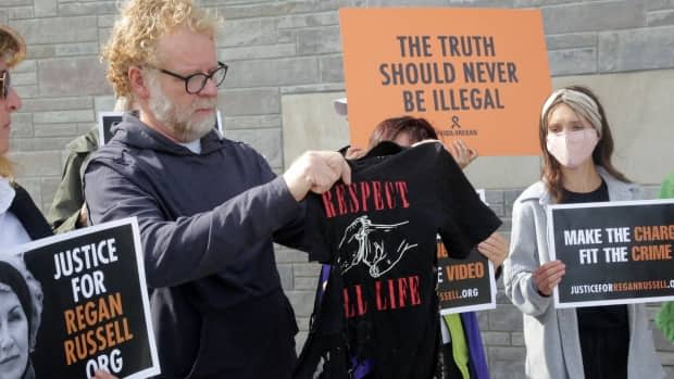 Mark Powell, widower of animal rights activist Regan Russell, holds the shirt she was wearing when she died.  (Samantha Craggs/CBC - image credit)