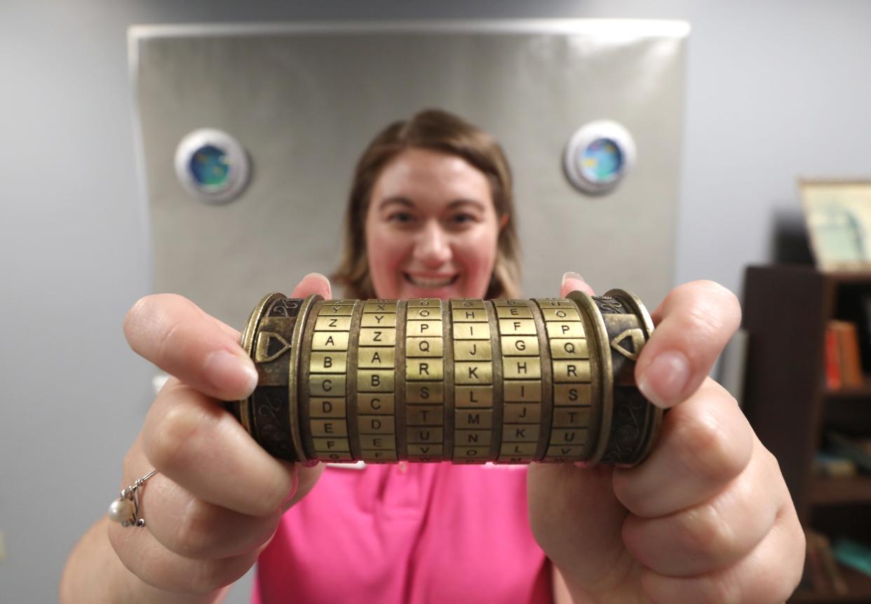 Muskingum County Library System Adult Services Librarian Heather Phillips holds up one of the clues to the John McIntire Libarary's escape room. 