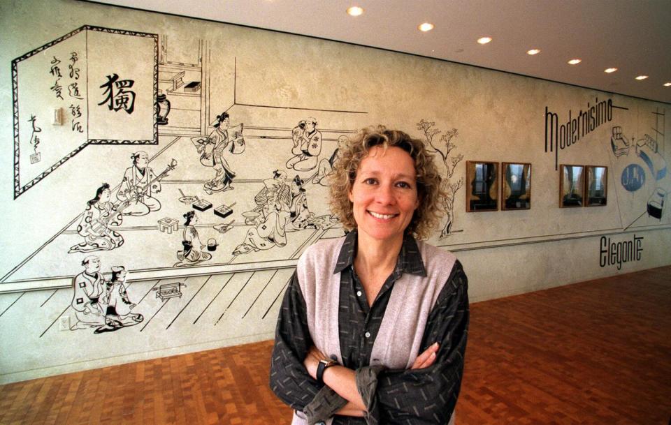 Alexis Smith stands in front of a mural with her arms crossed.