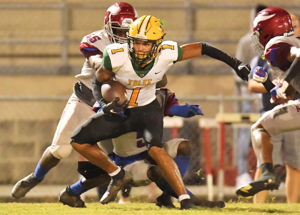 Yulee receiver Zack Drawdy (1) tries to escape Raines defenders during an October 2021 game.