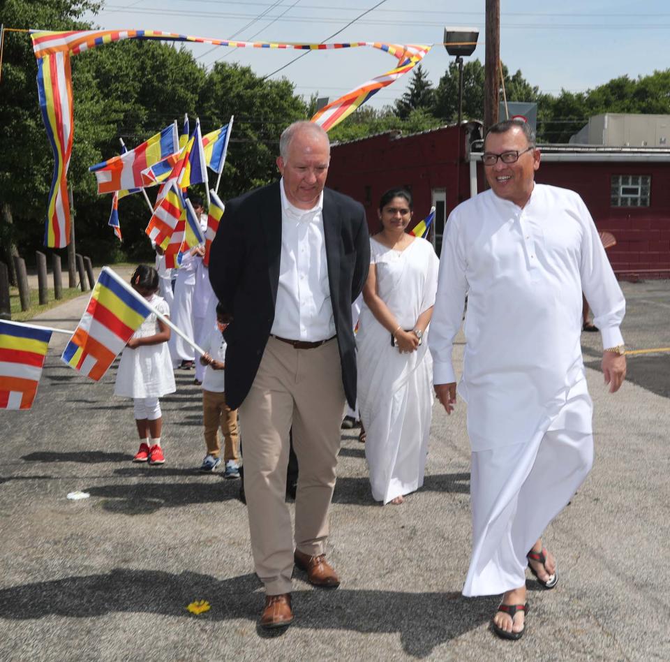 Akron Mayor Dan Horrigan, left, and Sri Lanka's ambassador to the U.S., Mahinda Samarasinghe, join the Procession of Maha Sangha leading to the dedication ceremony for the new Akron center.