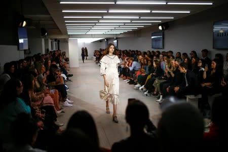 Members of the public watch models present creations at the Alexa Chung public catwalk show during London Fashion Week in London