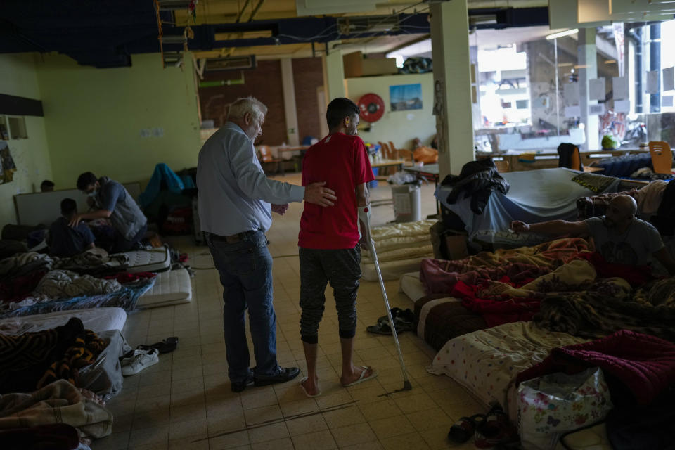 A man on hunger strike is helped by a volunteer as he occupies with others a big room of the ULB Francophone university in Brussels, Tuesday, June 29, 2021. (AP Photo/Francisco Seco)