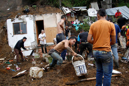 People and rescue agencies look for bodies in a destroyed area after mudslides, caused by heavy rains leading several rivers to overflow, pushing sediment and rocks into buildings and roads, in Manizales, Colombia April 19, 2017. REUTERS/Santiago Osorio