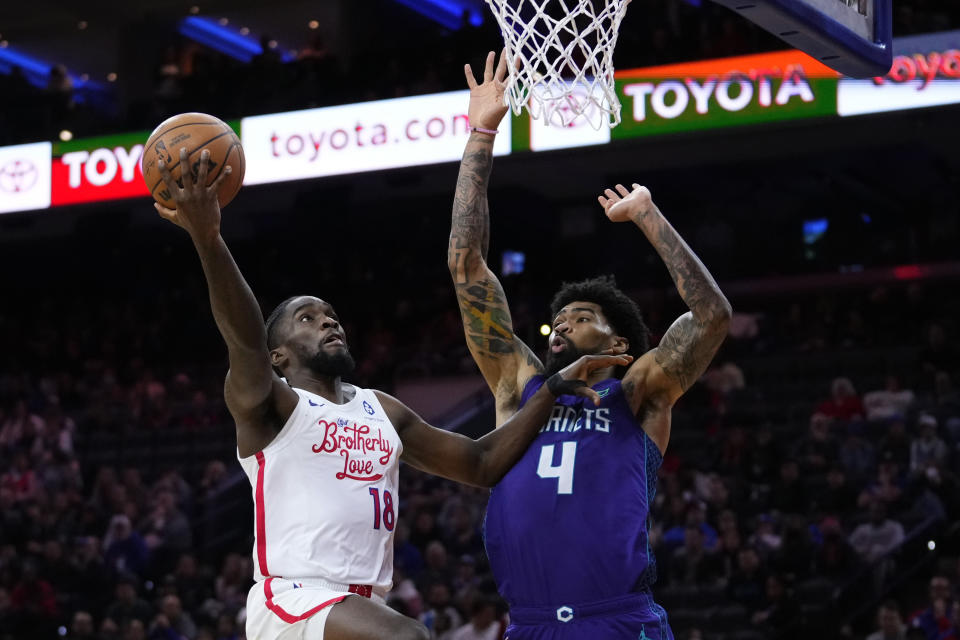 Philadelphia 76ers' Shake Milton, left, goes up for a shot against Charlotte Hornets' Nick Richards during the second half of an NBA basketball game, Sunday, Dec. 11, 2022, in Philadelphia. (AP Photo/Matt Slocum)