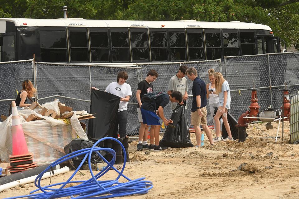 Volunteers from Cape Fear Academy work to pick up trash at Eden Village Tuesday May 24, 2022 off Kornegay Avenue in Wilmington, N.C.