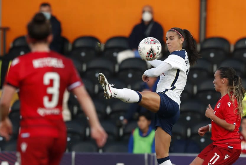 Tottenham Hotspur's Alex Morgan center, vies for the ball with Reading's Natasha Harding during the English Women's Super League soccer match between Tottenham Hotspur and Reading at the Hive stadium in London Saturday, Nov. 7, 2020. Morgan came on as a 69th minute substitute, the game ended in a 1-1 draw. (AP Photo/Alastair Grant)