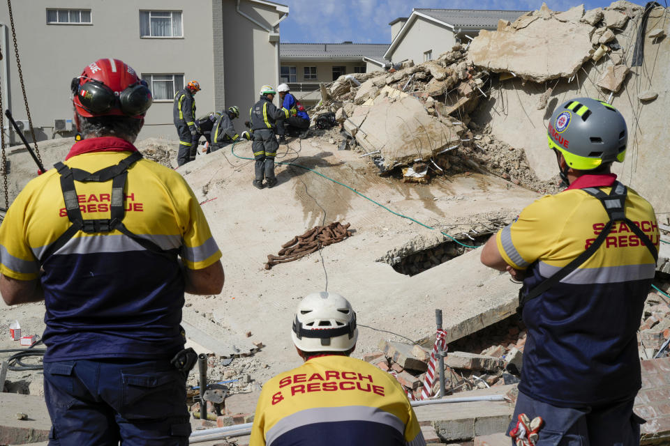 Rescue workers search the site of a building collapse in George, South Africa, Wednesday, May 8, 2024. Rescue teams are searching for dozens of construction workers missing after a multi-story apartment complex collapsed in the coastal city have brought out more survivors as the operation entered a second night of desperate work to find anyone alive in the mangled wreckage. (AP Photo/Jerome Delay)