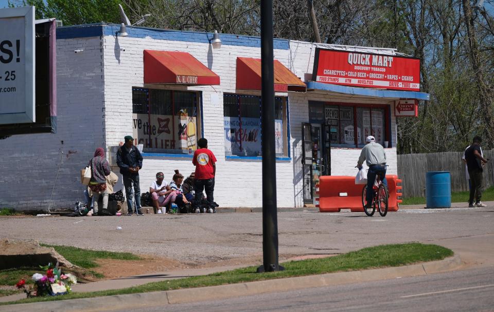 People hang out April 4  at the QuickMart next to the Relax Inn on NE 23.