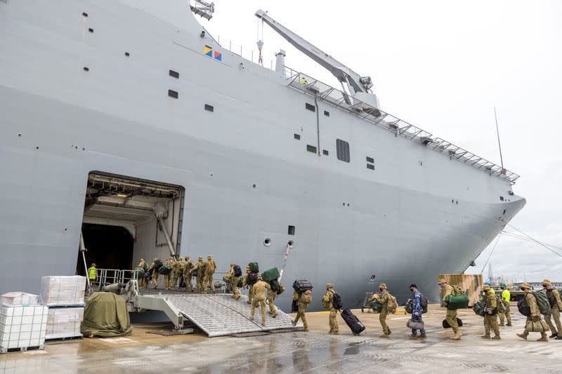 Members of the Australian Defence Force embark on HMAS Adelaide at the Port of Brisbane before departure to Tonga, in Brisbane