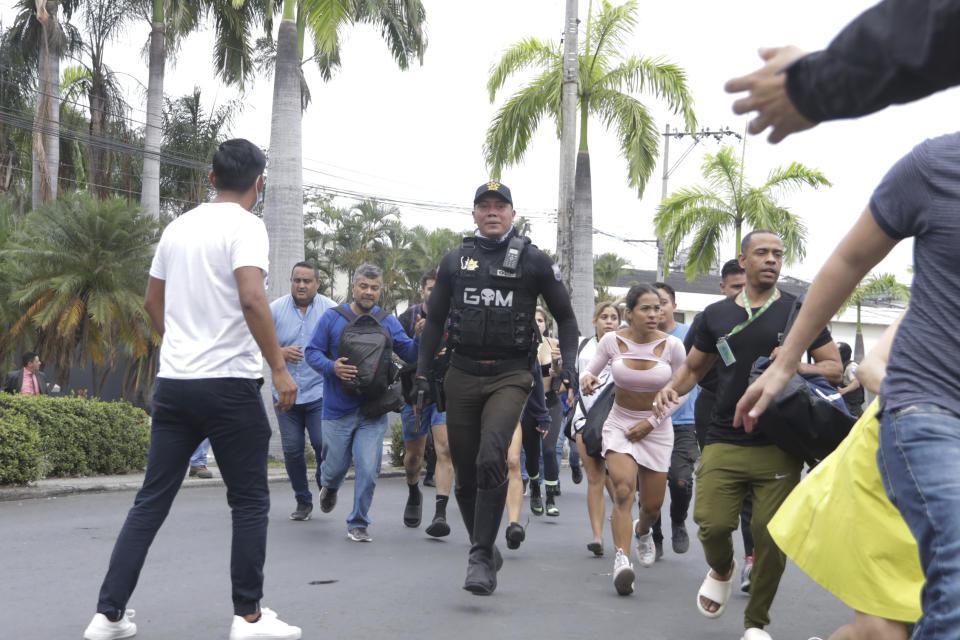 La policía evacúa a personal del canal TC Televisión después de que un grupo armado y encapuchado irrumpiera en plena transmisión en directo, en Guayaquil, Ecuador, el martes 9 de enero de 2024. El país ha registrado una secuencia de ataques violentos desde que el gobierno decretara el estado de excepción el lunes 8 de enero, tras la presunta fuga de un peligroso cabecilla de una banda criminal que opera en el país. (AP Foto/César Muñoz)