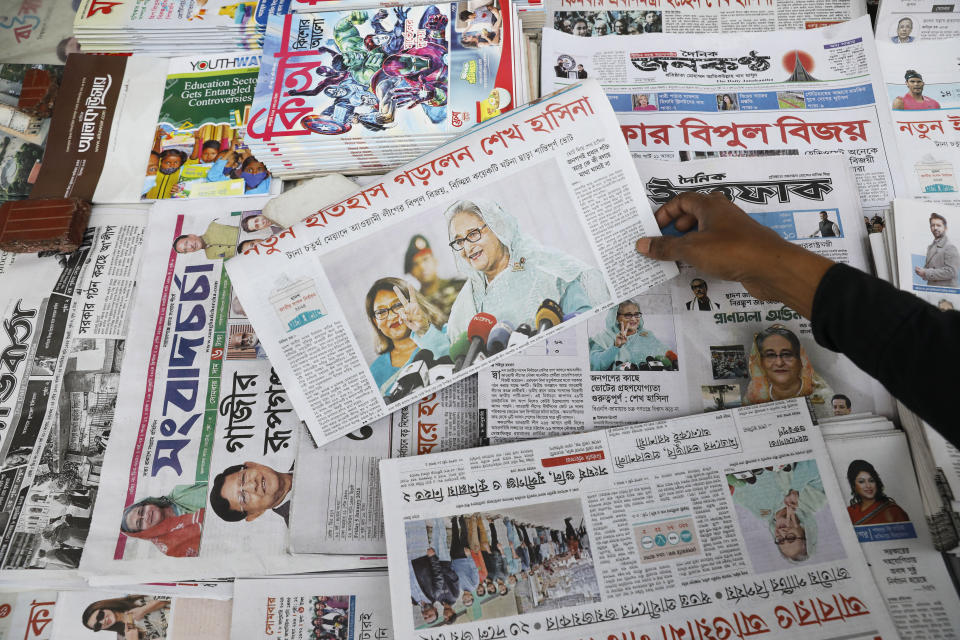 A man holds a Bangladeshi newspaper that has the news of Prime Minister Sheikh Hasina's election victory in Dhaka, Bangladesh, Monday, Jan.8, 2024. Hasina has won an overwhelming majority in Bangladesh's parliamentary election after a campaign fraught with violence and a boycott from the main opposition party, giving her and her Awami League a fourth consecutive term. (AP Photo/Mahmud Hossain Opu)
