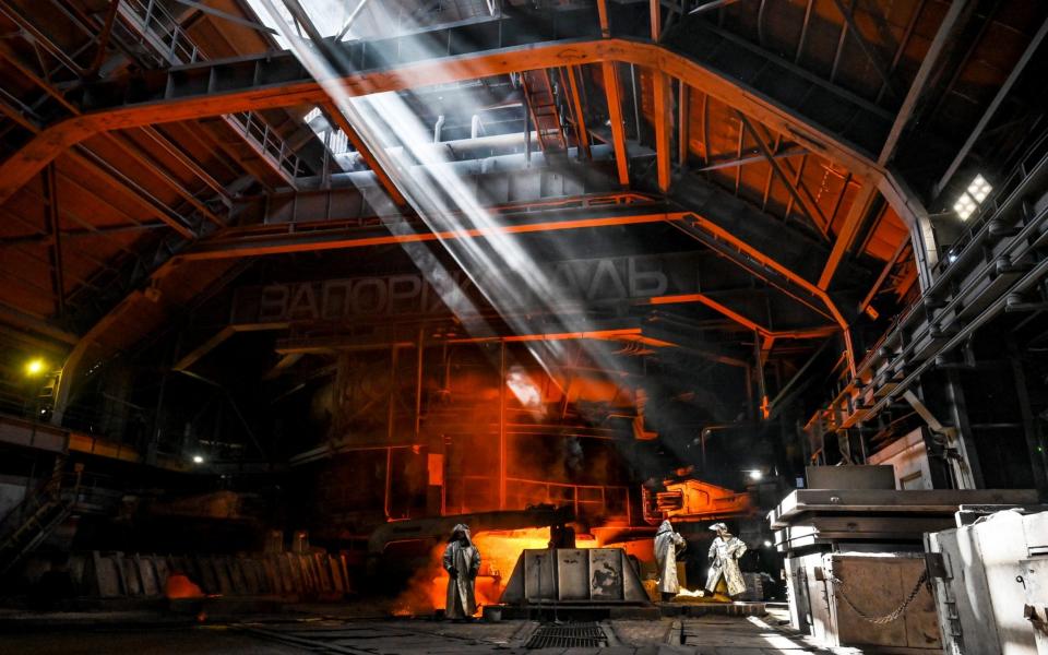 Employees in heat-resistant suits are seen at work in a foundry yard of blast furnace N3 at Zaporizhstal PJSC, Zaporizhzhia, southeastern Ukraine - Dmytro Smolyenko / Avalon