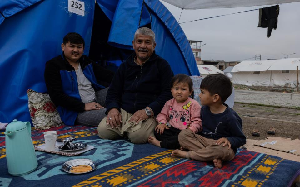 Shamsuddin Nouri, 63, with his 31-year-old son, Khaled, and grandchildren at the camp in Ovakent, Hatay - Stefanie Glinski