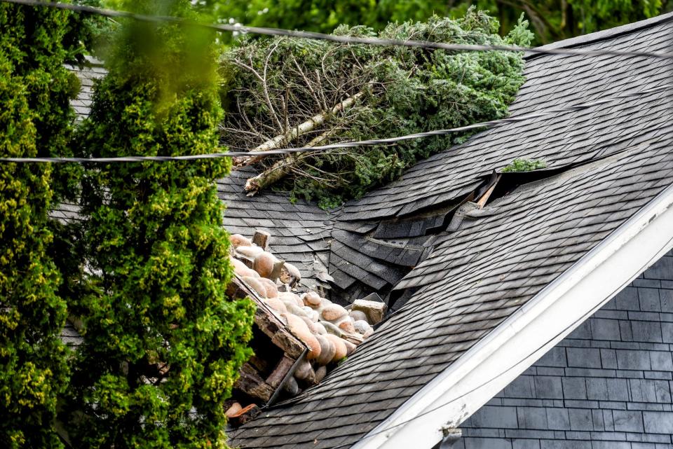 A toppled chimney caused damage to a roof after the storm on Thursday, July 13, 2023, on Lansing's east side.