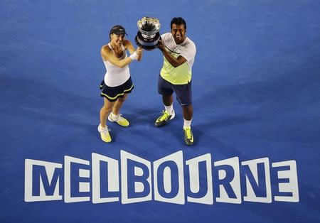 Martina Hingis (L) of Switzerland and Leander Paes of India pose with their trophy after defeating Kristina Mladenovic of France and Daniel Nestor of Canada to win their mixed doubles final match at the Australian Open 2015 tennis tournament in Melbourne February 1, 2015. REUTERS/Carlos Barria