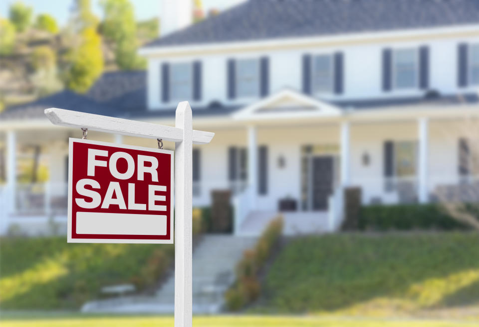 Home For Sale Real Estate Sign in Front of Beautiful New House.