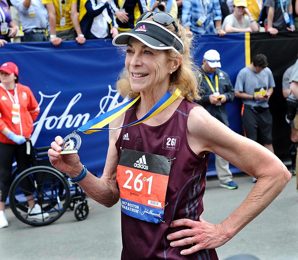 Pioneering woman marathoner Kathrine Switzer holds her medal after finishing the 2017 Boston Marathon, exactly  fifty years after her historic appearance in the Marathon, when as the first woman to run as a registered runner,  she famously fended off a race official who tried to stop her.