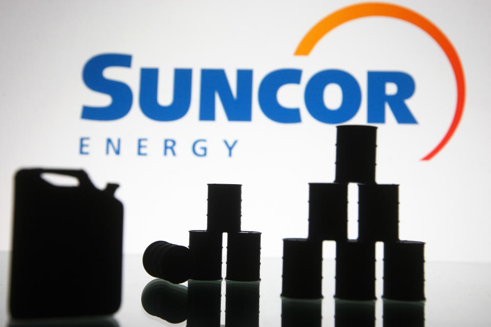Suncor Energy logo and models of a fuel an and oil barrels are pictured in this illustration photo taken in Kyiv on 19 August, 2021. (Photo by STR/NurPhoto via Getty Images)