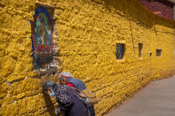 Members of the Tibetan Buddhist faithful pay their respects at a holy site at the base of the Potala Palace in Lhasa in western China's Tibet Autonomous Region, as seen during a rare government-led tour of the region for foreign journalists, Tuesday, June 1, 2021. Long defined by its Buddhist culture, Tibet is facing a push for assimilation and political orthodoxy under China's ruling Communist Party. (AP Photo/Mark Schiefelbein)