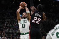 Jayson Tatum (derecha) de los Celtics de Boston dispara ante Jimmy Butler del Heat de Miami, en las finales de la Conferencia Este de la NBA, el lunes 23 de mayo de 2022. (AP Foto/Charles Krupa)