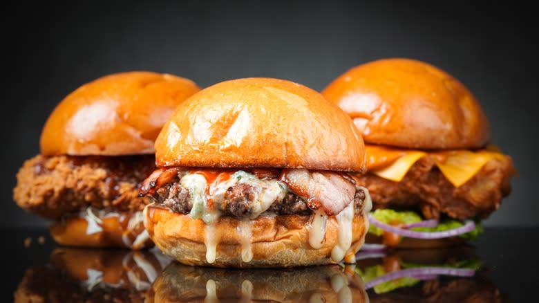 three burgers on dark background