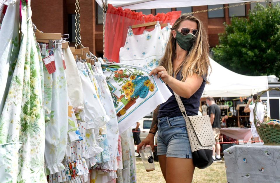 Jaci Maracle holds up her clothing find for friends to see while shopping the tents at the Providence Flea in 2020.