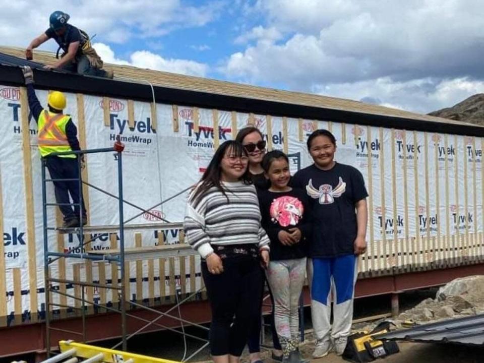 Neoma Cox, back, along with her three daughters stand in front of their future house. The family was selected as recipient of the home by Habitat for Humanity Iqaluit.  (Submitted by Neoma Cox - image credit)