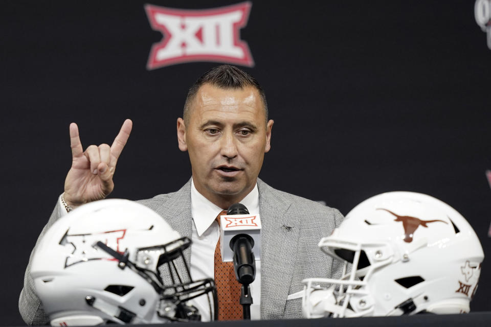 Texas head coach Steve Sarkisian flashes a quick Hook 'em Horns sign as finishes up speaking to reporters at the NCAA college football Big 12 media days in Arlington, Texas, Thursday, July 14, 2022. (AP Photo/LM Otero)