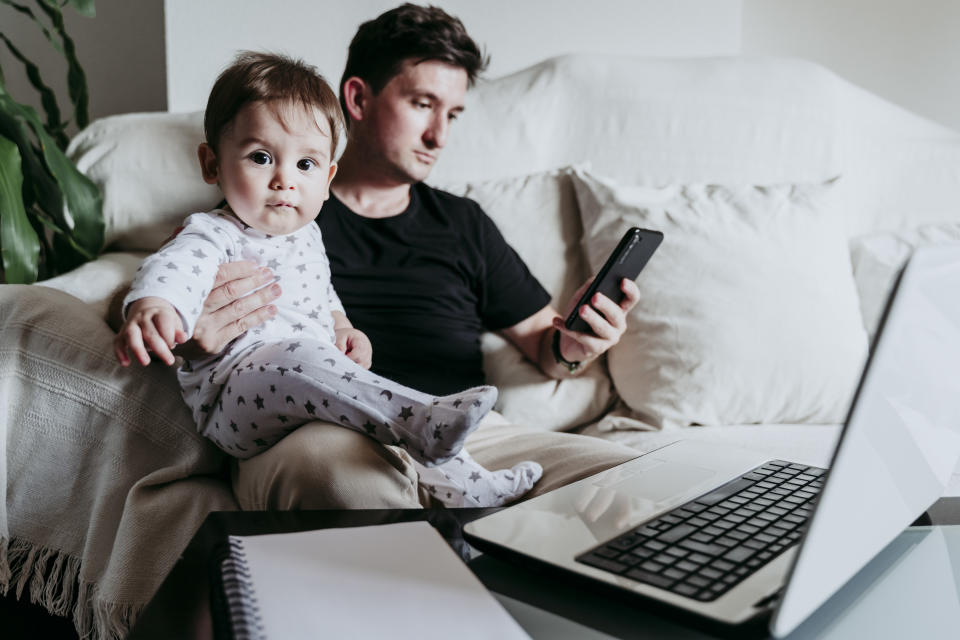 man on phone while looking after baby