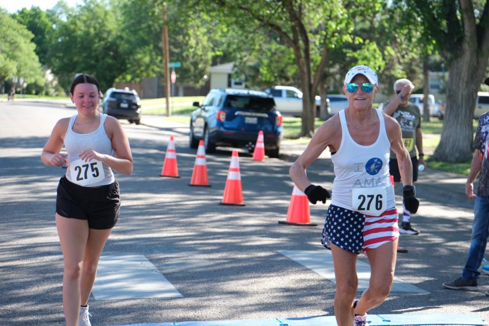 Two runners celebrate at the finish of the Chief Petty Officer Jack R. Barnes Run For the Fallen Saturday morning at Stephen F Austin Park in Amarillo.