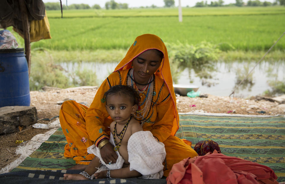 Rihanna clothes her son Rehan after bathing him with rainwater on the side of the road, where many like her are camping after their homes were devastatedSaiyna Bashir/Arete/WFP