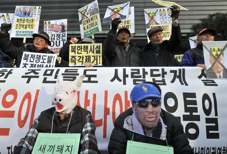 South Korean conservative activists wear masks of a pig (L) symbolizing North Korean leader Kim Jong-Un and former NBA star Dennis Rodman during an anti-North Korea rally marking the birthday of Kim in Seoul on January 8, 2014