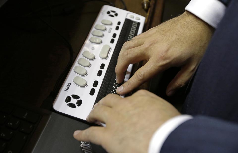 Washington Lt. Gov.-elect Cyrus Habib rests his fingers on a braille display on the Senate chamber dais, Thursday, Jan. 5, 2017, during a practice session to test technical equipment in Olympia, Wash. Habib, who will preside over the Senate, will be Washington's first blind lieutenant governor, and the Senate has undergone a makeover that incorporates Braille into that chamber's floor sessions that will allow Habib to know by the touch of his finger which lawmaker is seeking to be recognized to speak. Habib is replacing Lt. Gov. Brad Owen, who is retiring. (AP Photo/Ted S. Warren)