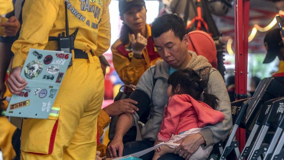 A man carrying a child receives medical attention at a temporary rescue command post after being rescued from the Taroko National Park in Hualien on April 5. Picture: I-Hwa Cheng / AFP