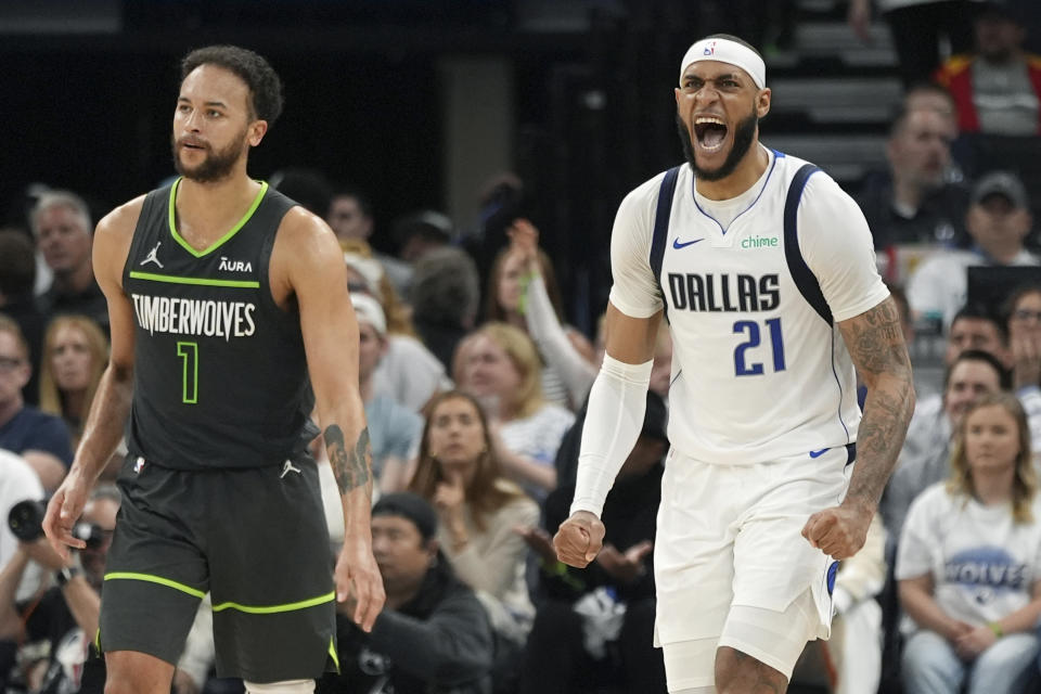 Dallas Mavericks center Daniel Gafford (21) celebrates a Minnesota Timberwolves shot clock violation as Minnesota Timberwolves forward Kyle Anderson (1) pauses on the court during the first half of Game 5 of the Western Conference finals in the NBA basketball playoffs, Thursday, May 30, 2024, in Minneapolis. (AP Photo/Abbie Parr)