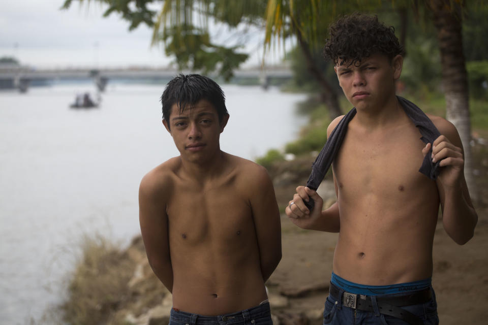 Honduran brothers Francisco Nazario, left, and Abdiel Manuel Alvarado, pose for a portrait at the border between Guatemala and Mexico, in Tecun Uman, Guatemala, Saturday, Oct. 20, 2018. The brothers said they began their journey with their mother Graciela and 7-year-old brother, but they weren't able to reach the border with them. "I don't want to be in that hole anymore, said Nazario, referring to Honduras. "I want to improve myself," he added. (AP Photo/Moises Castillo)