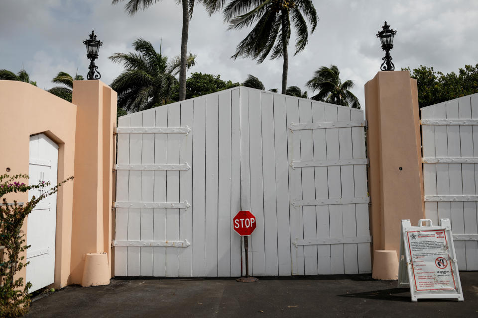 A stop sign in front of a gated entrance to Mar-a-Lago.