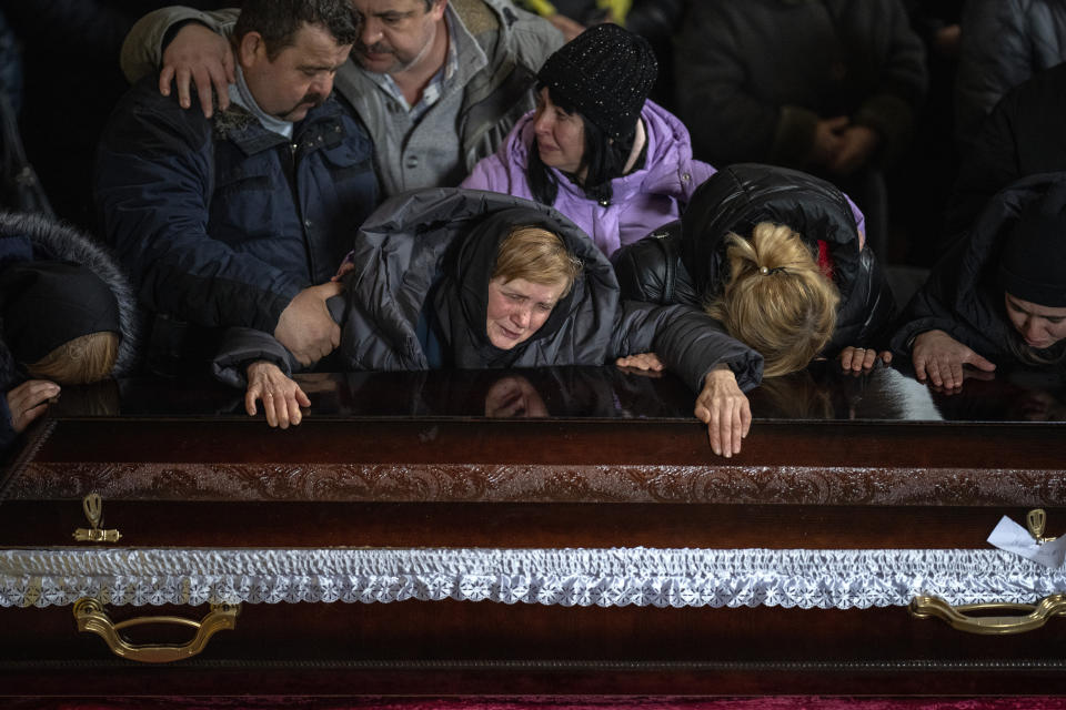 Nadia cries over the coffin of her son Oleg Kunynets, a Ukrainian military servicemen who was killed in the east of the country, during his funeral in Lviv, Ukraine, Tuesday, Feb 7, 2023. (AP Photo/Emilio Morenatti)