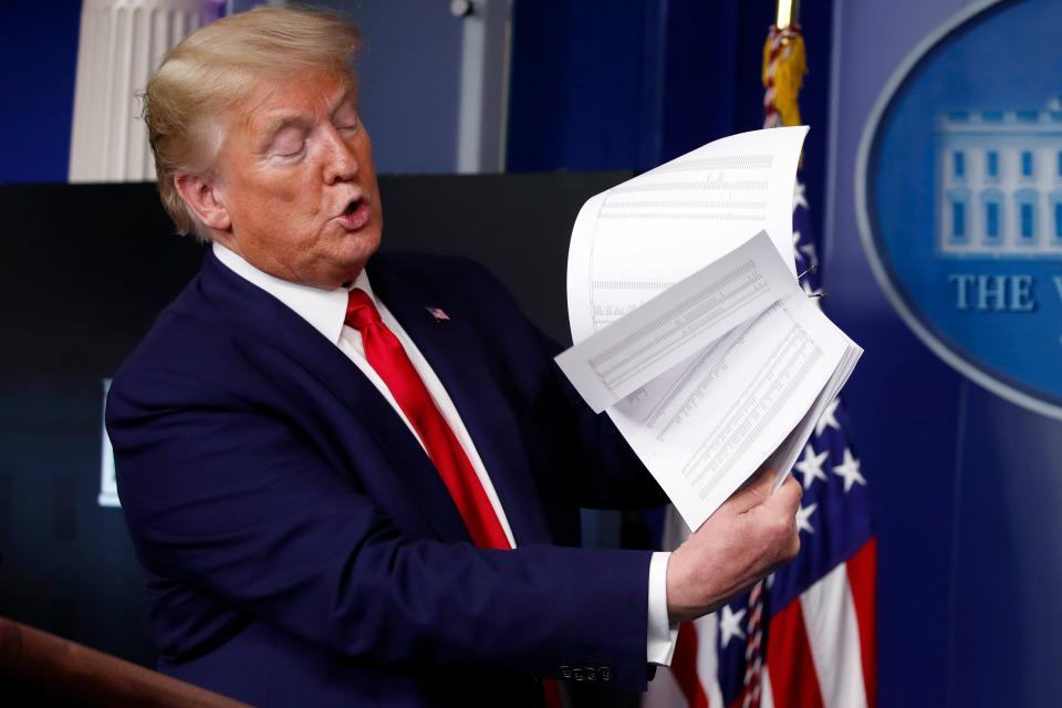President Donald Trump flips through a stack of papers as he speaks about the coronavirus in the James Brady Press Briefing Room of the White House, Monday, April 20, 2020.