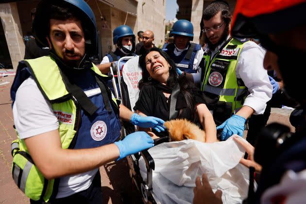 <p>Une femme tient son chien alors qu'elle est évacuée par des médecins après qu'une roquette a été lancée depuis la bande de Gaza, à Ashkelon, dans le sud d'Israël.</p>